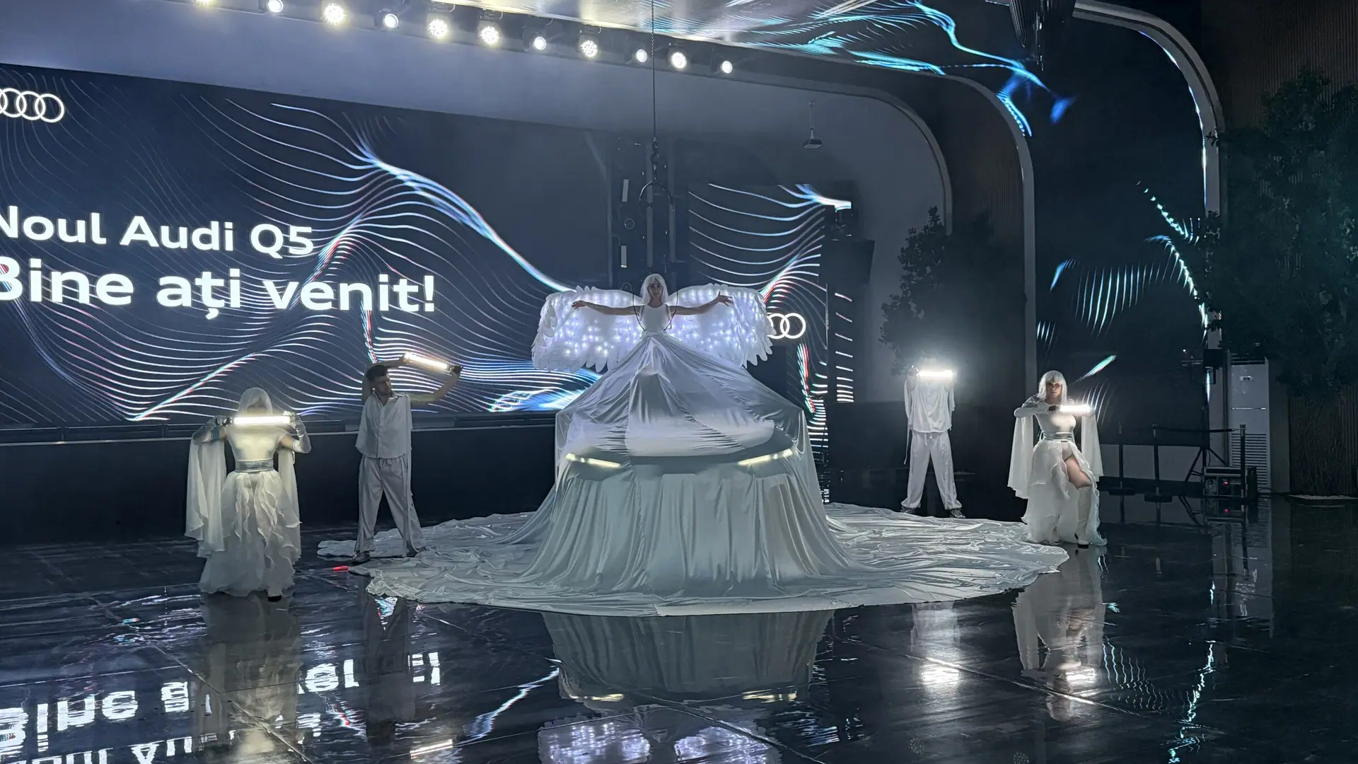 Performers in white suits with LED wings, a veil dress made from 80 metres of fabric, and the new Audi Q5 underneath.