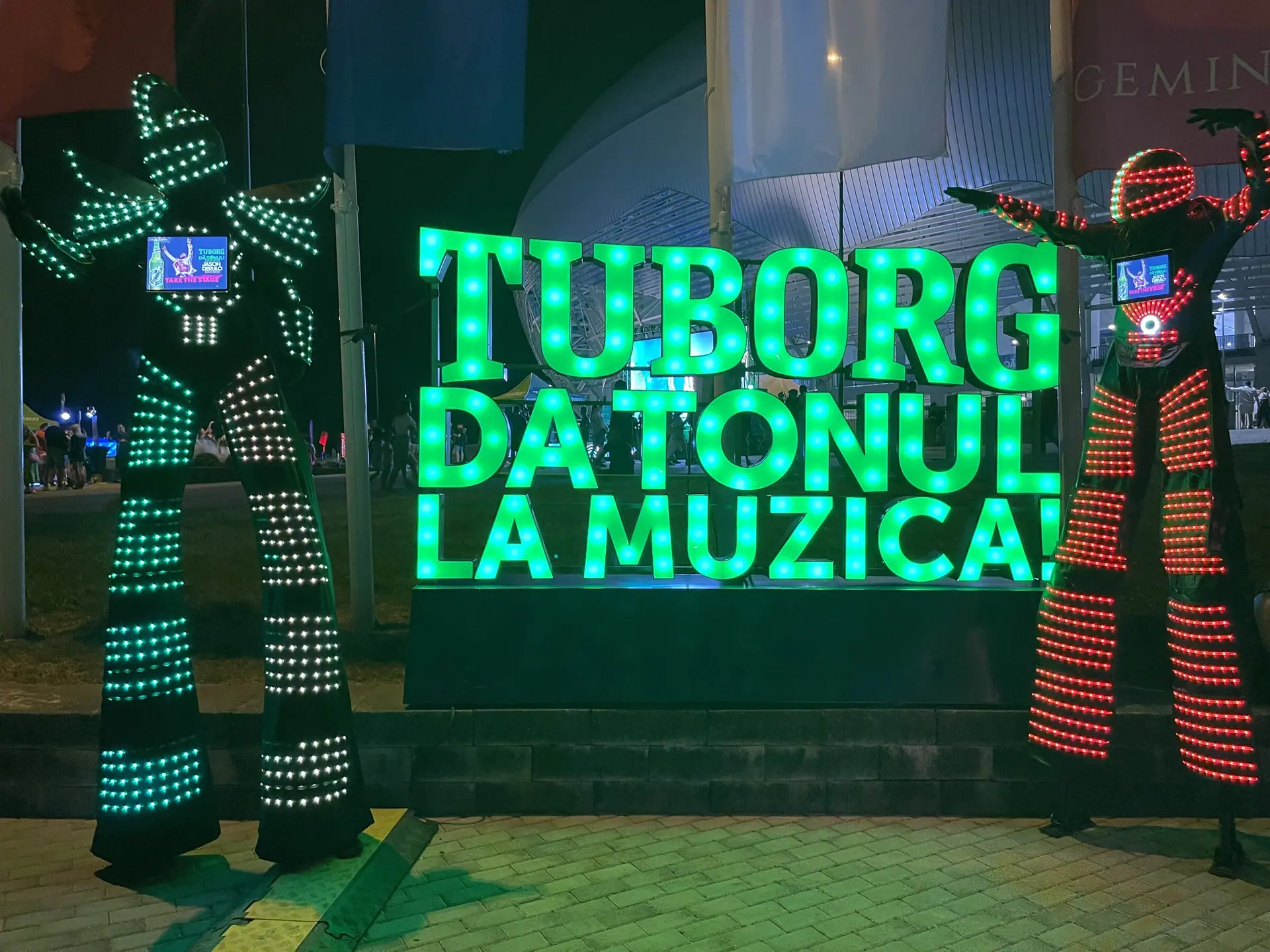 Two LED robots on stilts, screens on their chests, walking the IntenCity stadium crowd and stopping at the Tuborg zone.