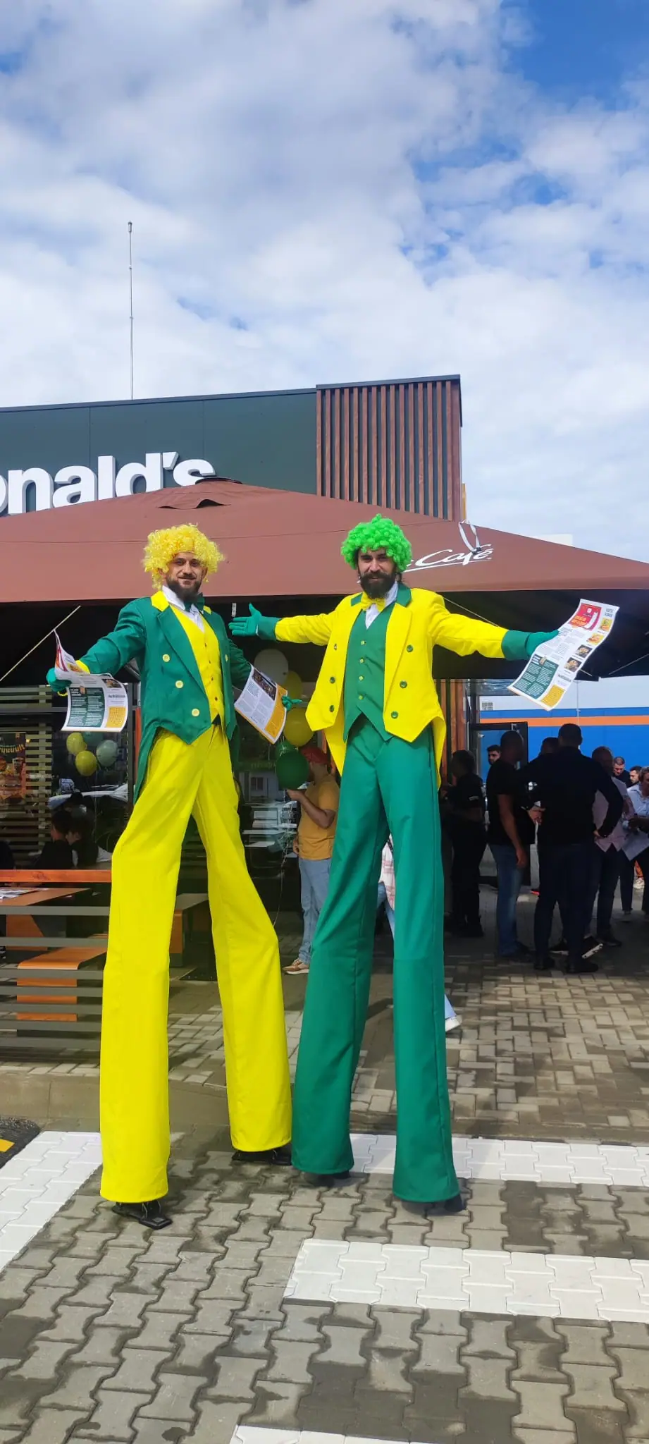 Two stilt performers in costumes built to the brand's colours, welcoming customers at the restaurant door.